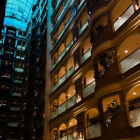 Madinah Hilton Hotel Medina Exterior photo The photo shows the interior of a modern building, likely a hotel or a high-rise. The space features multiple floors with balconies that overlook a central atrium. The atrium is illuminated with warm lighting, enhancing the architectural details of t