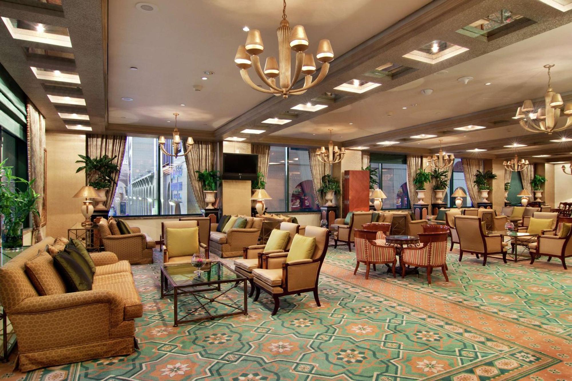 Madinah Hilton Hotel Medina Exterior photo The photo shows an elegant lounge or sitting area, featuring a spacious layout with stylish furniture. The room is filled with various seating options, including plush chairs and sofas, arranged around small tables. The decor includes decorative plan