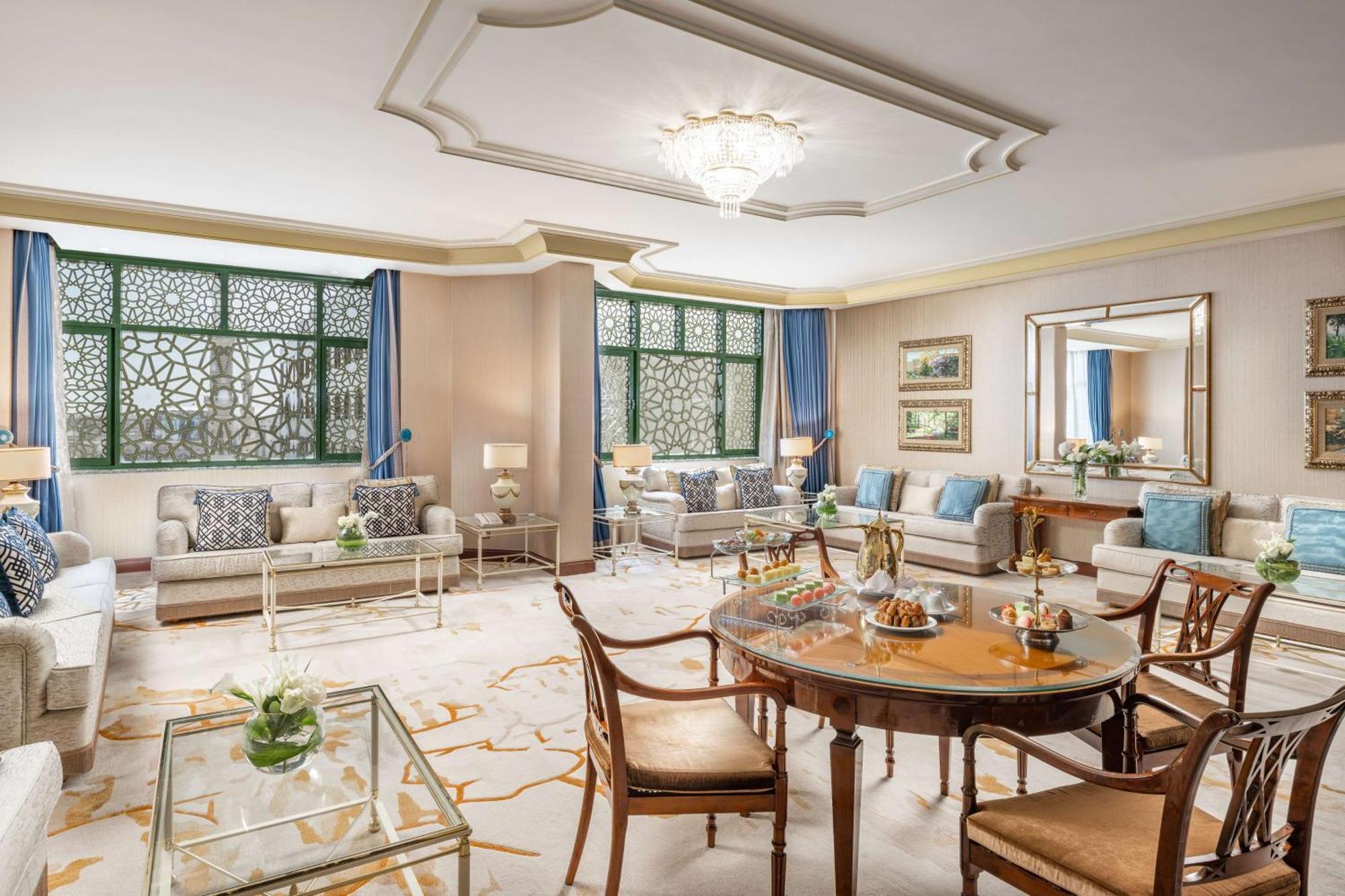 Madinah Hilton Hotel Medina Exterior photo The image shows a spacious and elegantly designed living room. The room features large windows with intricate patterns, allowing natural light to fill the space. The walls are painted in a soft color, providing a warm ambiance. 

There are comfortabl