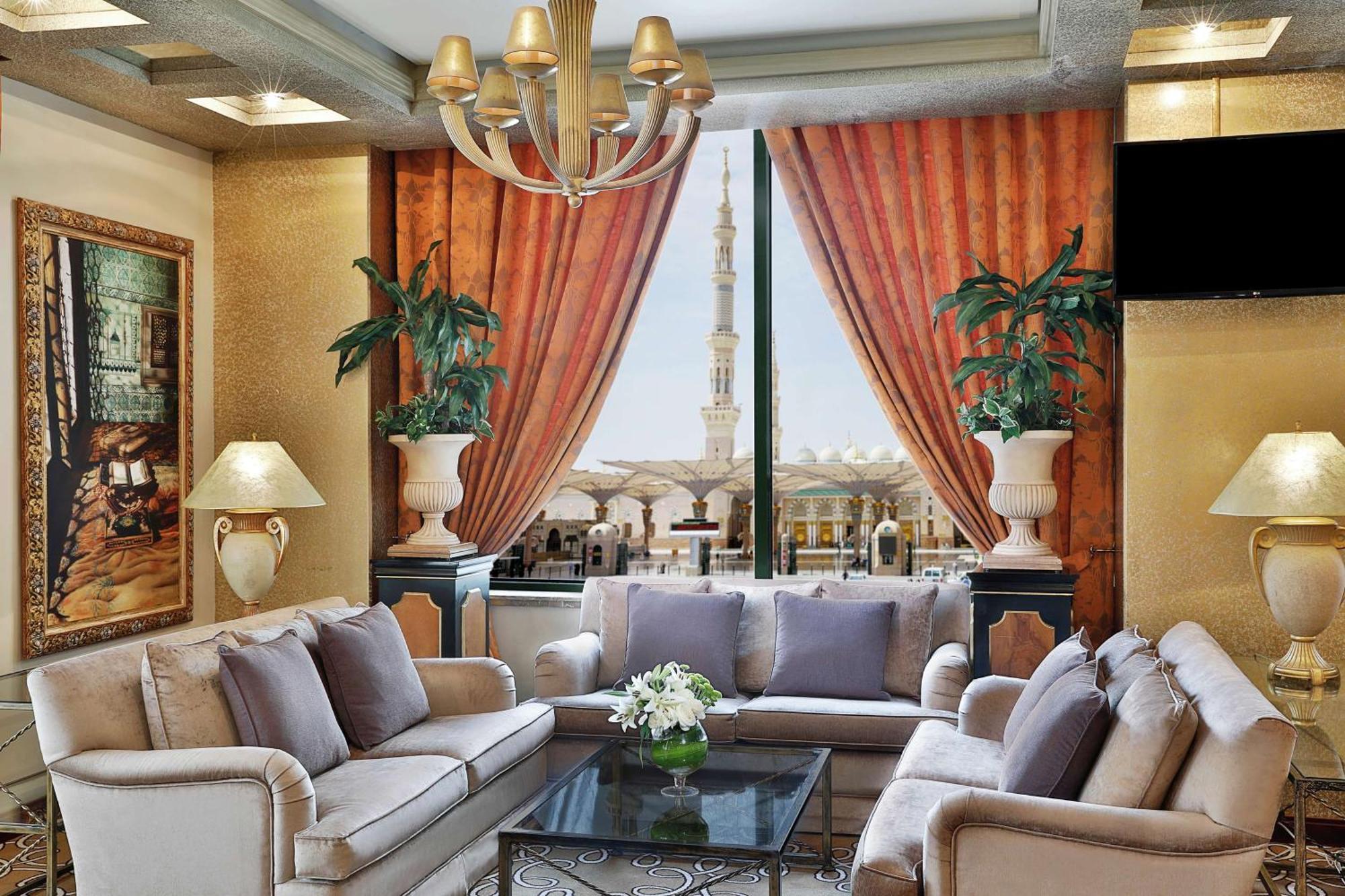 Madinah Hilton Hotel Medina Exterior photo The photo shows a luxurious interior of a living room. It features elegant furniture, including a light-colored sofa with decorative cushions, and a glass-topped coffee table. The walls are decorated with art pieces, and there are potted plants addin