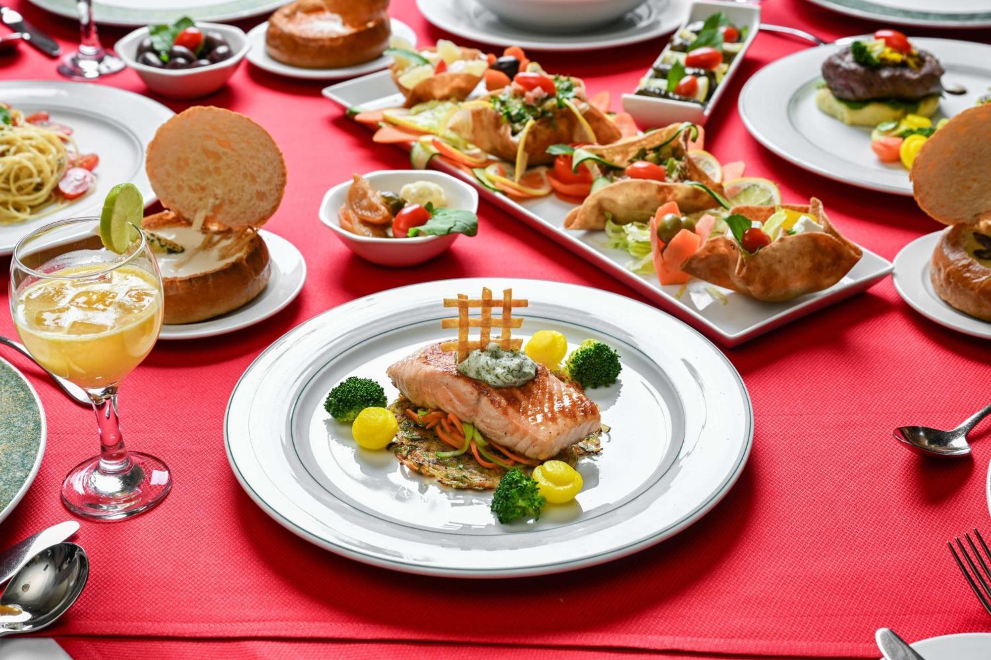 Madinah Hilton Hotel Medina Exterior photo The photo showcases a beautifully arranged table set with a variety of dishes. In the center, there's a plated portion of salmon garnished with herbs, broccoli, and yellow fruit or vegetable puree, decorated with a hashtag symbol made of crispy pastr